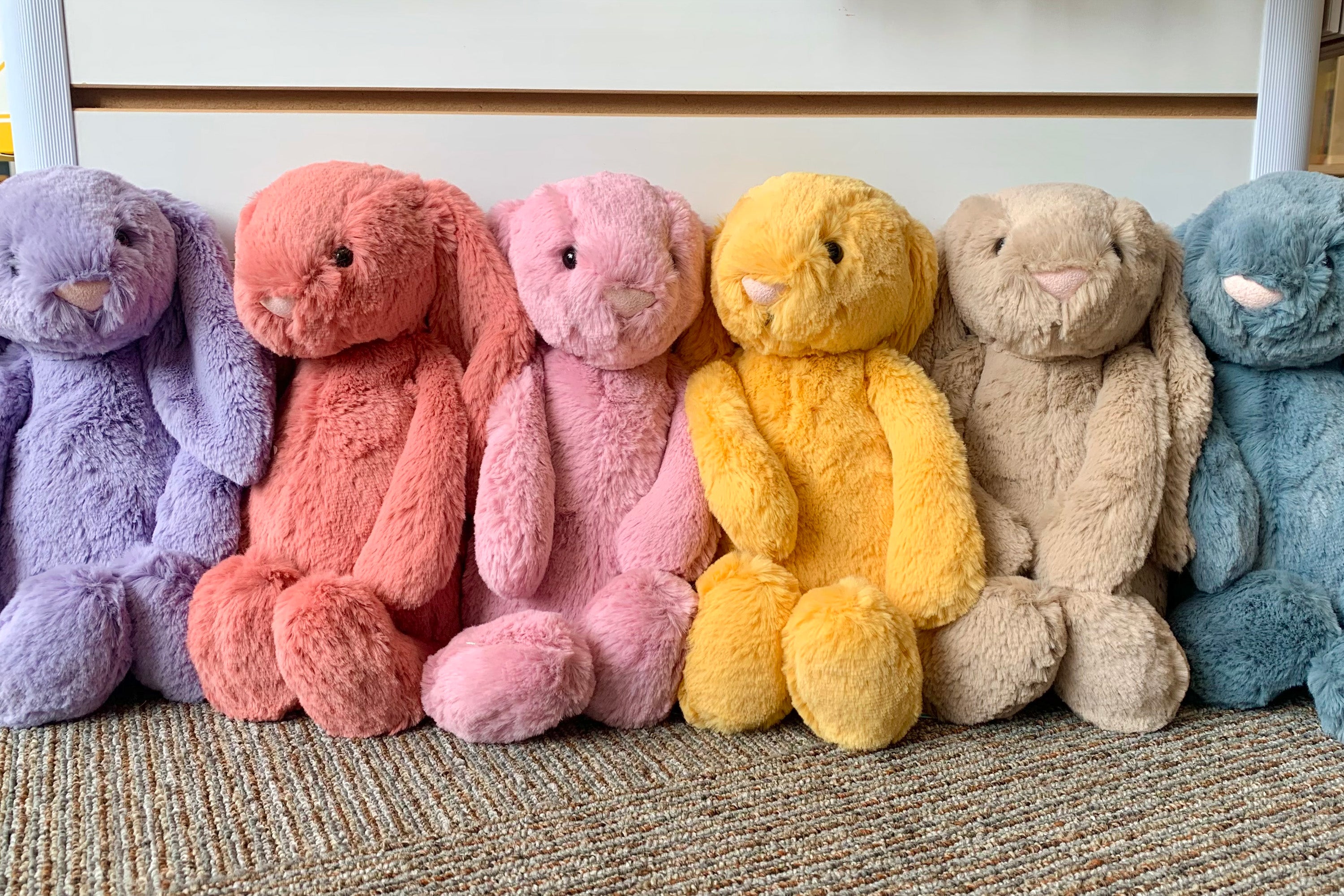 jellycat bashful bunnies in different colors, from left to right: violet, sorrel, pink, yellow, beige, dusky blue